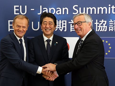 Prime Minister Shinzo Abe of Japan (center) is welcomed in Brussels by Donald Tusk, president of the European Council, and Jean-Claude Juncker, right, president of the European Commission.