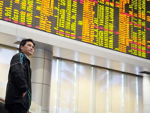 Illustrative purposes only: An Investor stands in front of private stock trading boards at a private stock market gallery in Kuala Lumpur, Malaysia. 
