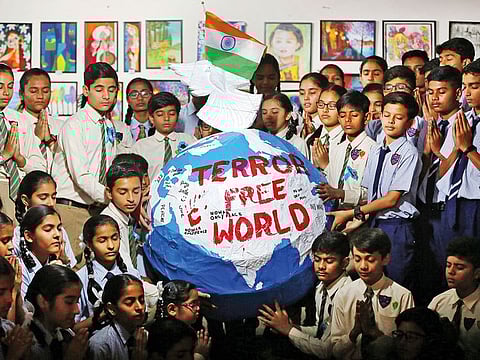Students pray around a replica of planet Earth with messages about peace, to pay tribute to Central Reserve Police Force (CRPF) personnel who were killed after a suicide bomber rammed a car into the bus carrying them in south Kashmir last week, inside a school in Ahmedabad, India.