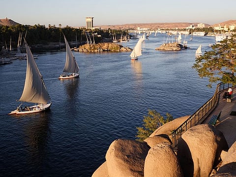 Traditional boats sailing on the Nile river in Aswan, Egypt. 
