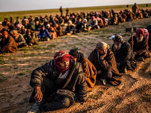 en suspected of being Daesh fighters wait to be searched by members of the Kurdish-led Syrian Democratic Forces (SDF) after leaving the IS group's last holdout of Baghouz in Syria's northern Deir Ezzor province, on February 22, 2019. 