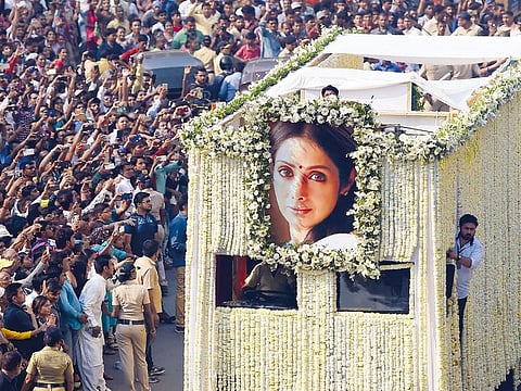 Fans watch as the funeral cortege for Sridevi passes through Mumbai on February 28, 2018. 
