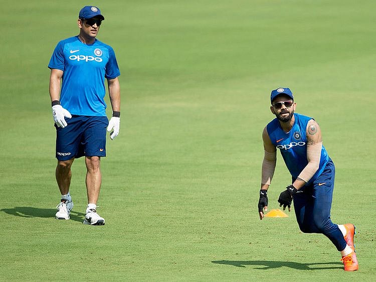 Mahendra Singh Dhoni, left, watches Virat Kohli