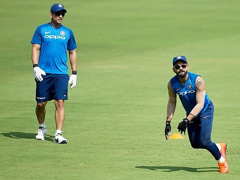Mahendra Singh Dhoni, left, watches Virat Kohli as they attend a practice session on the eve of their first T20 cricket match against Australia, in Visakhapatnam, India, Saturday, February 23, 2019.  