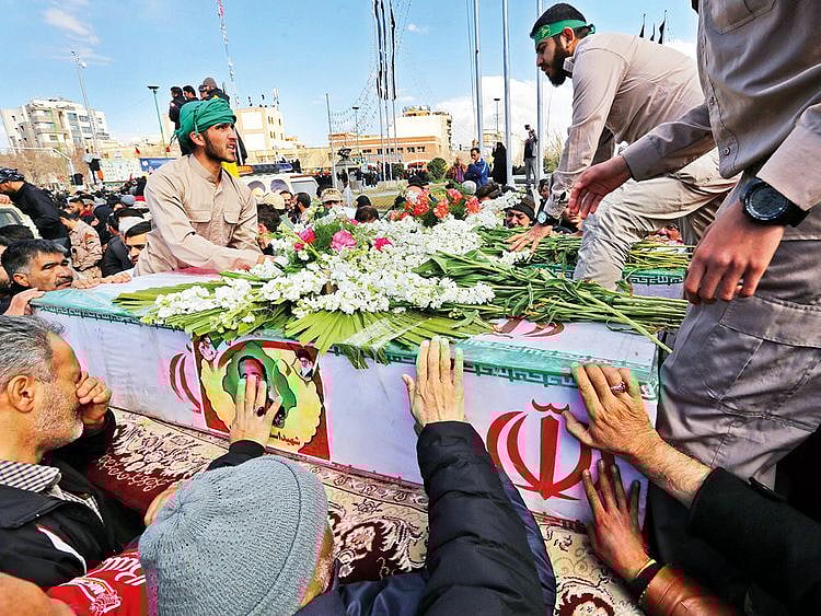 Relatives touch the coffin of a member of the Revolutionary Guards