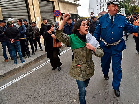 Algerian policeman tries to disperse a protest against Algeria's president candidacy for a fifth term, on February 22, 2019 in Algiers. Abdelaziz Bouteflika's decision to seek a fifth term as president stirred mixed reactions in the Algerian society. 