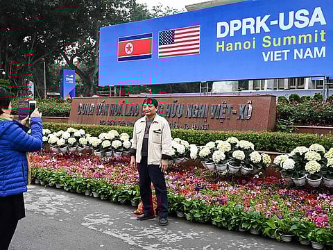 A man has his picture taken with a billboard for the second US-North Korea summit, in Hanoi. 