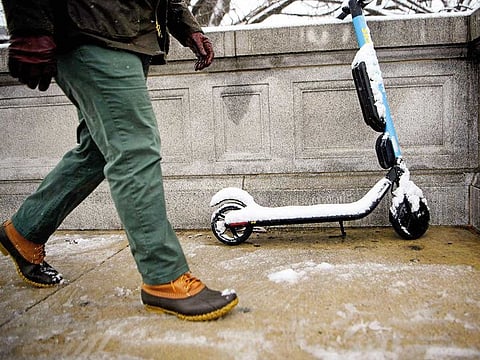 A person walks past a sharable electric scooter during winter weather on February 20 in Washington, DC.