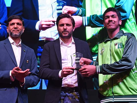 Shahid Afridi, former captain of the Pakistan cricket team, presents the award to Sinan Ashfaq Ahmad, in the presence of Dr Faisel Ikram.