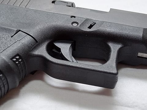 A close up of a black semi automatic pistol. For illustrative purposes only.