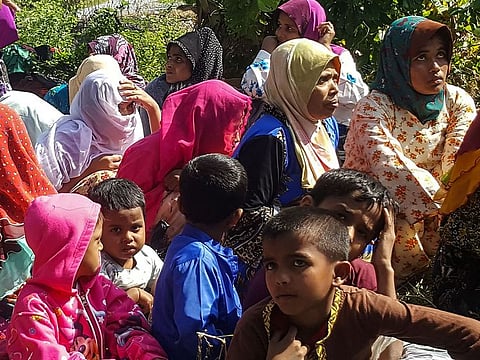 Rohingya refugees, who landed on an isolated northern shore near the Malaysia-Thai border, huddle in a group in Kangar on March 1, 2019, following their detention by Malaysian immigration authorities. 