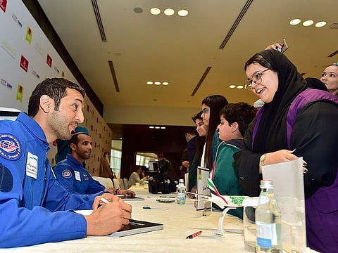 Astronauts Sultan Al Neyadi (L) and Hazzaa Al Mansouri (2nd L) sign the Race To Space books at the Emirates Airline Festival of Literature in March 2019