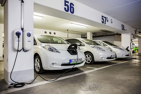 Electric automobiles charge in a parking lot in Berlin.  