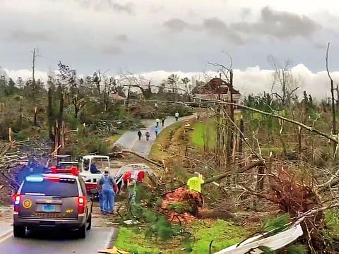 People clear fallen trees and debris on a road following a tornado in Beauregard, Alabama, U.S. in this March 3, 2019 still image obtained from social media video. 