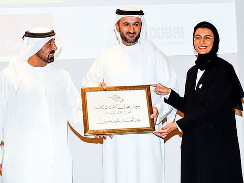 Shaikh Ahmad and Noura Al Kaabi present Personality of the Year award to Abdul Ghaffar Hussain received by his son Mohammad at the official ceremony of the Emirates Airlines Festival of Literature. 