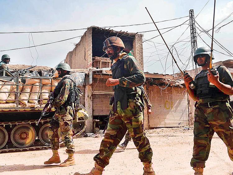 Pakistani soldiers patrol an empty bazaar