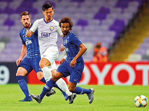 Hilal's defender Hassan Kadesh (R) vies for the ball with Ain's defender Tsukasa Shiotani during the AFC champions league Group C football match between UAE's Al-Ain and Saudi Arabia's Al Hilal at the Hazza Bin Zayed Stadium in Al-Ain 