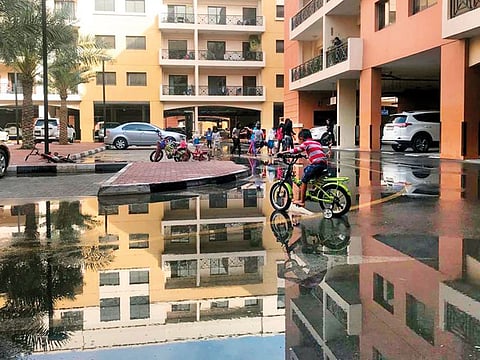 Children playing in rain water at a residence area in Ras Al Khor in Dubai after rain on Wednesday evening.