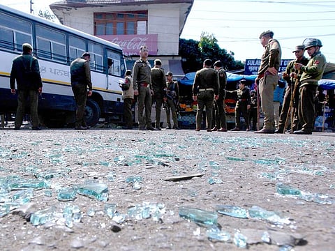 Indian police inspect the site of a grenade blast at a bus station in Jammu.