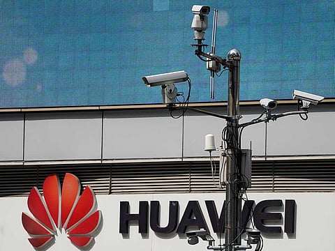 Surveillance cameras are seen next to a Huawei company logo outside a shopping mall in Shanghai, China, March 7, 2019. 