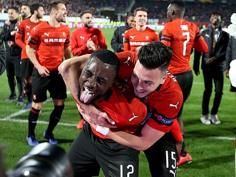 Rennes' Ramy Bensebaini and James Lea Siliki celebrate after the match.