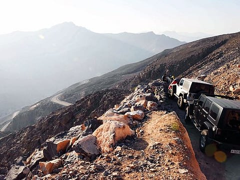 A group of visitors manages to find a vantage point to chill and soak up the magnificent view of the Hajar Mountains.