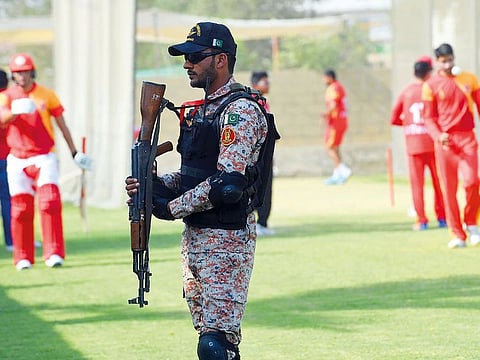 A Pakistani soldier stands guard as Islamabad United crikceters take part in a training session at the National Cricket Stadium in Karachi