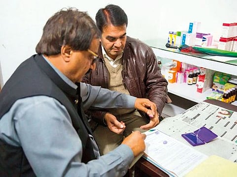 Dr Saeed Asghar (left), deputy director anti-quackery department raids, takes a confession statement from Muhammad Kashif, an unqualified doctor.