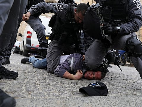 Israeli police officers detain a Palestinian protestor during scuffles outside the compound housing Al Aqsa Mosque in Jerusalem's Old City