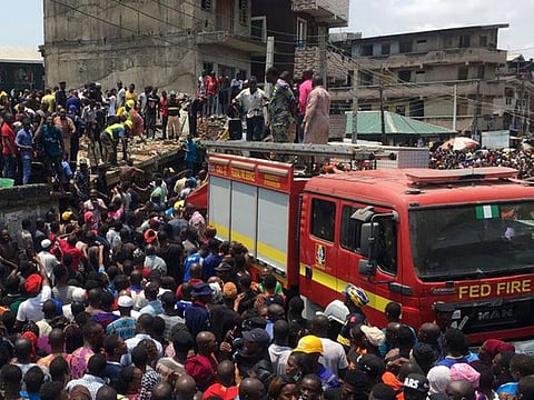 Rescue workers are seen at the site of a collapsed building containing a school in Nigeria's commercial capital of Lagos, Nigeria