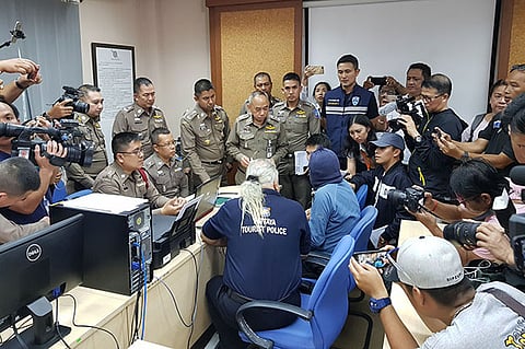 Wael Zureikat (hooded) being question by Thai police