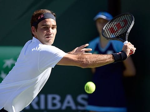 Roger Federer, of Switzerland, returns a shot to Kyle Edmund, of Britain, at the BNP Paribas Open tennis tournament Wednesday, March 13, 2019, in Indian Wells, California. 