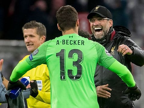 Liverpool’s coach Jurgen Klopp celebrates with goalkeeper Alisson after the final whistle.