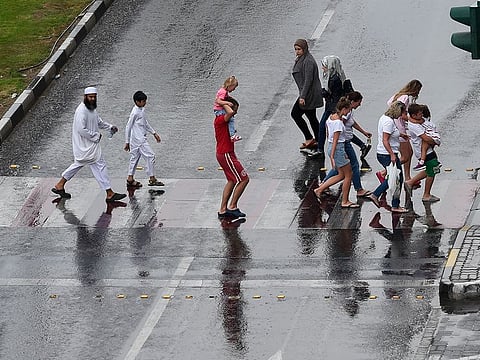 Residents caught in the rain in Sharjah on Friday afternoon.