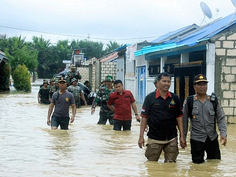 Indonesian police and soldiers search for residents who need assistance at a flooded neighborhood in Sentani, Papua Province, Indonesia, Monday, March 18, 2019. 