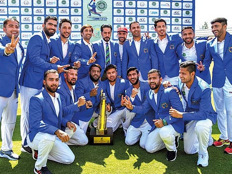 Afghanistan team members celebrate with the trophy after winning their first Test match by beating Ireland in Dehradun.