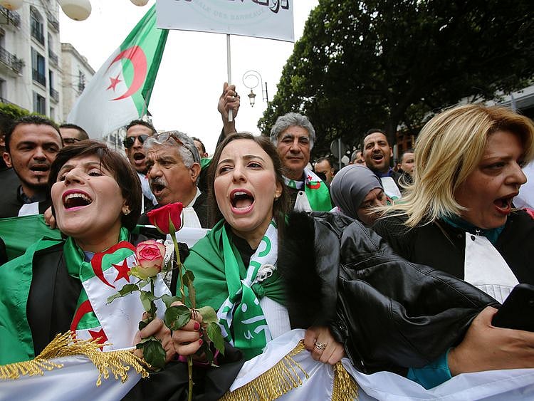 Lawyers carry national flags and flowers