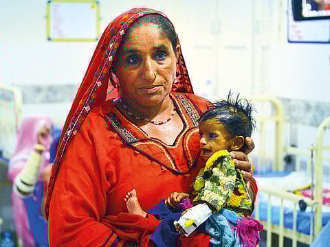 Nazeeran, a 25-year mother, holds her baby girl at Mithi Civil Hospital in Mithi, a remote town in southern Pakistan. 