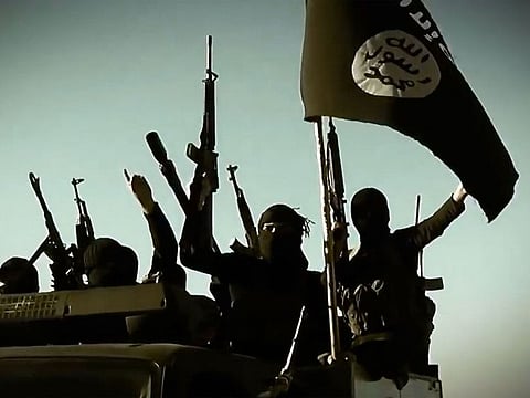 In this file image grab taken from a propaganda video released on March 17, 2014 by the Islamic State of Iraq and the Levant (ISIL)'s al-Furqan Media allegedly shows ISIL fighters raising their weapons as they stand on a vehicle mounted with the trademark Jihadists flag at an undisclosed location in the Anbar province.
