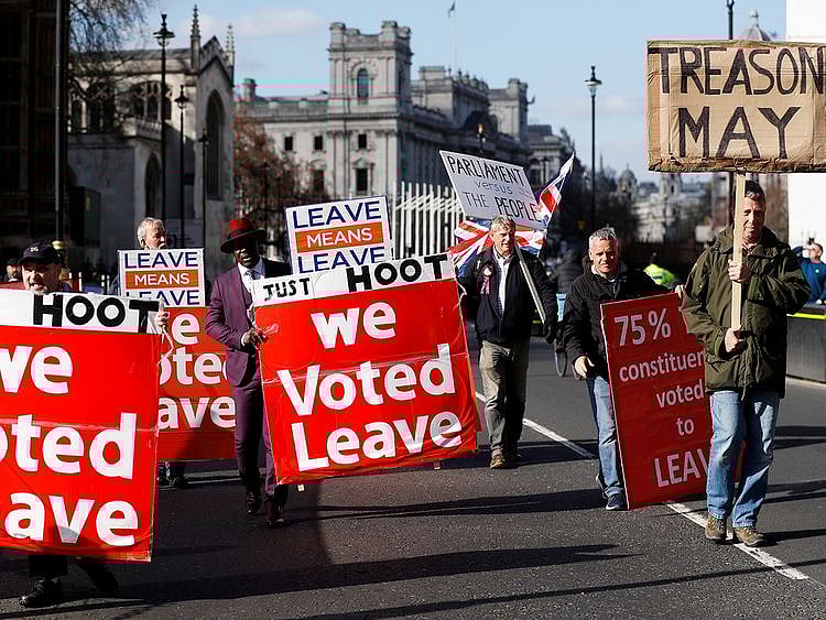 Pro-Brexit protesters walk outside the Houses of Parliament in London