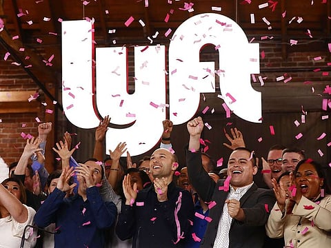 Confetti falls as Lyft CEO Logan Green (C) and President John Zimmer (LEFT C) ring the Nasdaq opening bell celebrating the company's initial public offering (IPO) on March 29, 2019 in Los Angeles, California.