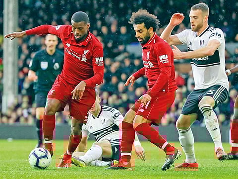 Liverpool's Georginio Wijnaldum, left, goes for the ball as Liverpool's Mohamed Salah looks at him, the English Premier League soccer match between Fulham and Liverpool at Craven Cottage stadium in London.
