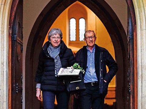 Britain's Prime Minister Theresa May (L) leaves with her husband Philip (R) after attending a church service, near her Maidenhead constituency, west of London on March 31, 2019.  