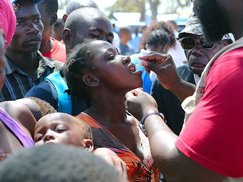 A woman receives an oral cholera vaccination at a camp for displaced survivors of cyclone Idai in Beira, Mozambique