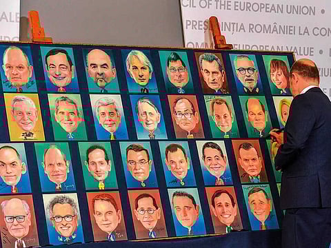 Germany’s Finance Minister Olaf Scholz signs a painted portrait of himself at an informal meeting of the EU Finance ministers in Bucharest yesterday.