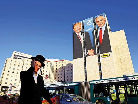 A man walks past a Likud election campaign billboard, depicting U.S. President Donald Trump shaking hands with Israeli Prime Minister Benjamin Netanyahu, in Jerusalem February 4, 2019