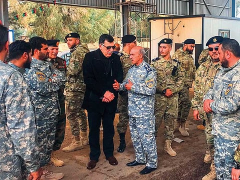 The head of Libya’s UN-backed unity government, Fayez Al Sarraj, shakes hands with military and security commanders of the government forces who supervised recapture of the checkpoint 27 in Janzour.