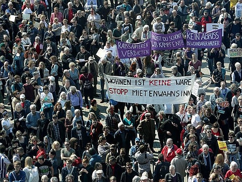 Protesters attend a demonstration against rent increase in Berlin, Germany, Saturday, April 6, 2019. Slogan in the foreground reads 'Living Is Not A Product - Stopp Rent Insanity'.