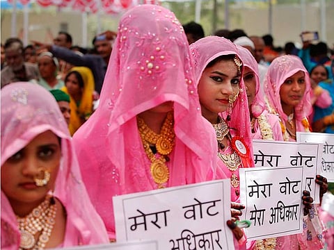 Muslim brides display placards to aware people on voting during a mass marriage ceremony at a mosque in Ahmedabad, Sunday, March 31, 2019. (PTI Photo)  (PTI3_31_2019_000037B)