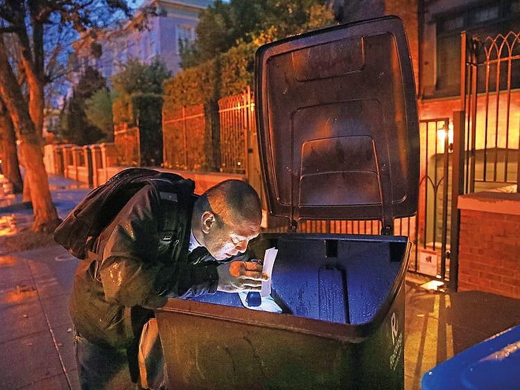 Jake Orta looks through a trash can